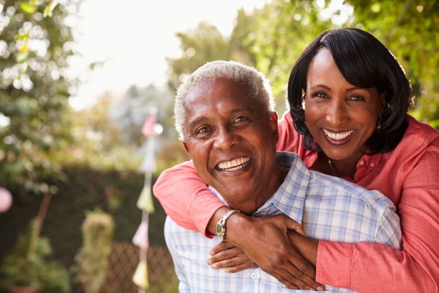 a woman hugging a man who is wearing a red shirt.